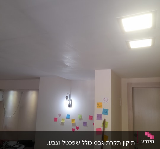 קיר גבס עם פתקים צבעוניים ומנורה